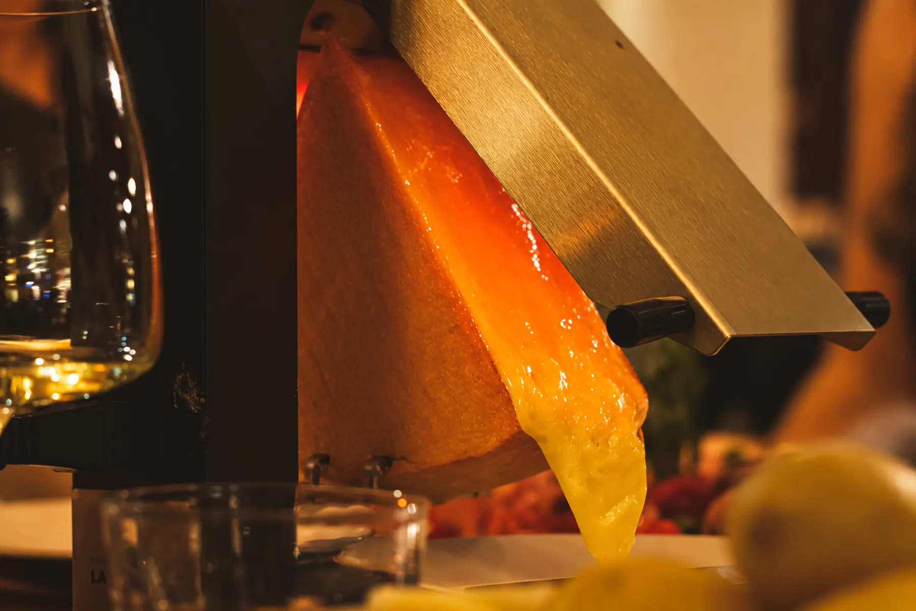 Raclette cheese turning golden and bubbling beneath the heating bar